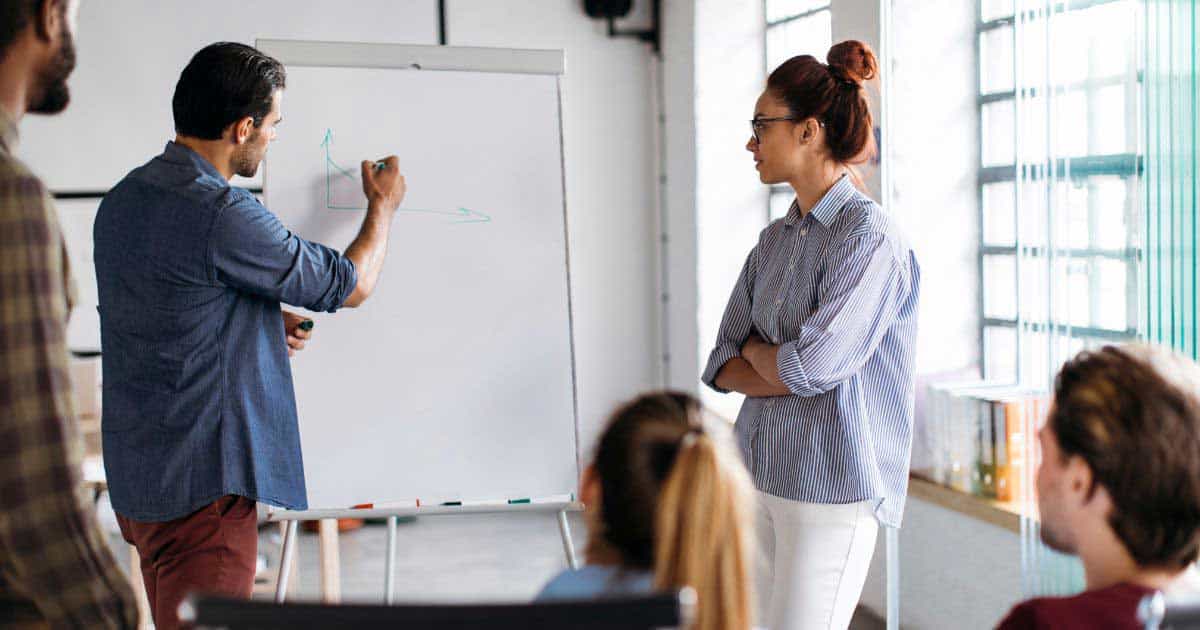 A man giving briefing using a white board 