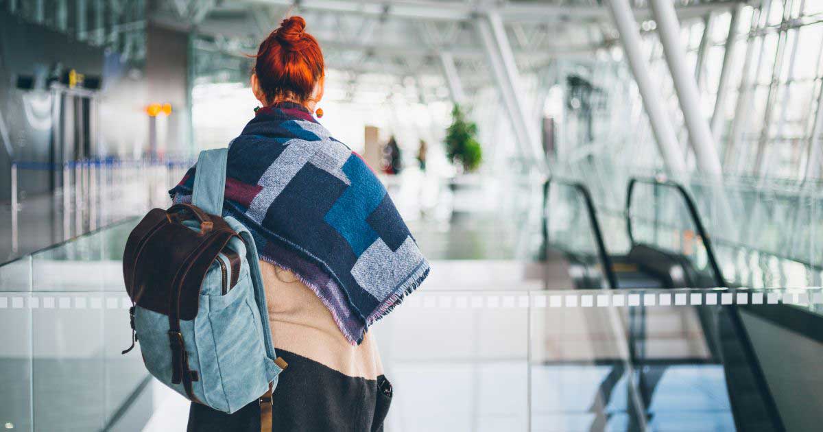 student with backpack in airport